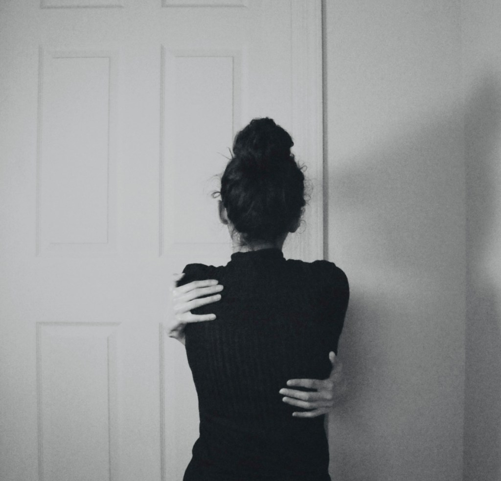 woman-hugging-herself-with-back-to-camera