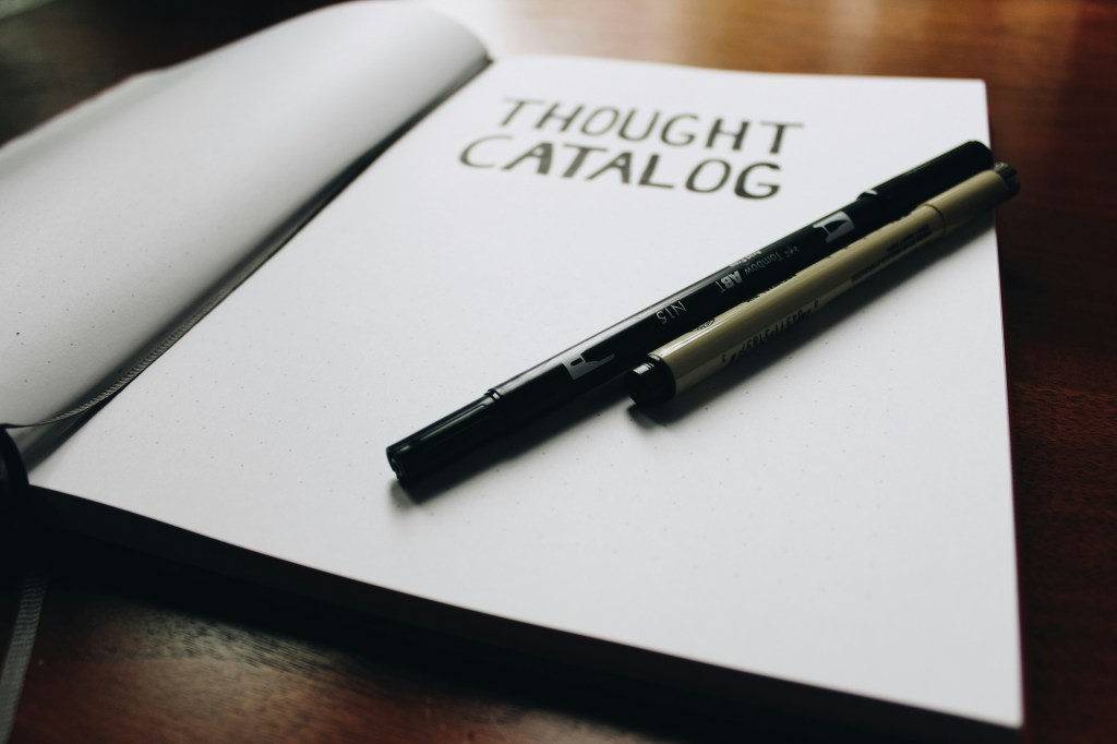 thought-catalog-written-in-journal-with-pens-on-table
